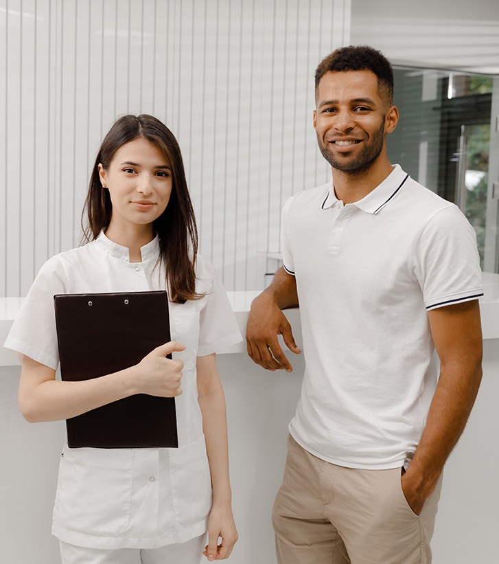 Smiling dental team members in front of desk