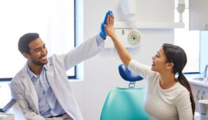 Happy patient high-fiving her dentist